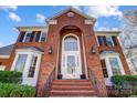 Close up of brick entrance featuring a white door with large window and black iron railing at 9239 Silver Pine Dr, Charlotte, NC 28277