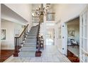 Bright foyer with a staircase, chandelier, and marble floors for an inviting ambiance at 9239 Silver Pine Dr, Charlotte, NC 28277