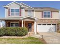 Attractive two-story home with stone accents, a covered front porch, and a spacious two-car garage at 1000 Sweetgum St, Gastonia, NC 28054