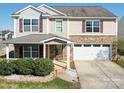 Inviting two-story home showcasing a stone-clad front, double garage, and manicured landscaping at 1000 Sweetgum St, Gastonia, NC 28054