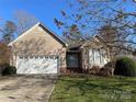 Traditional home featuring a well-maintained lawn, two-car garage, and classic architectural details at 104 Johnsbury Dr, Stanley, NC 28164
