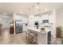 Bright, open kitchen with stainless steel appliances, quartz countertops, and a large center island at 141 Rhuidean Ct, Troutman, NC 28166