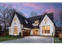 Striking home with black trim, a black roof, and a garage with a natural wood door at 1711 Brook Rd, Charlotte, NC 28205