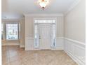 Bright foyer with tile flooring, paneled walls, and large windows, offering a grand entrance to the home at 178 Harper Lee St, Davidson, NC 28036