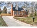 Lovely brick home featuring a well-maintained lawn, mature trees, and a long driveway leading to the property at 1815 Townes Ct, Rock Hill, SC 29730