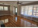 Bright living room with hardwood floors, large windows, and a ceiling fan at 1873 Rocky River Rd, Lancaster, SC 29720