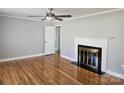 Cozy living room features gleaming hardwood floors, a ceiling fan, and a fireplace at 1873 Rocky River Rd, Lancaster, SC 29720