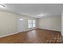 The open living room shows the large window, neutral walls and hardwood flooring at 208 Tomberlin Rd, Mount Holly, NC 28120