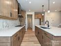 Spacious kitchen featuring wood cabinets, quartz countertops, stainless steel appliances, and modern backsplash at 209 Halemarg Dr, Belmont, NC 28012