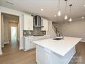 Modern kitchen featuring a large quartz island, stainless steel appliances, and stylish pendant lighting at 211 Halemarg Dr, Belmont, NC 28012