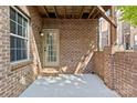 View of concrete patio with brick wall, exterior door, and a window at 225 Lincoln St, Charlotte, NC 28203