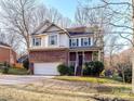 Charming two-story home featuring a brick facade, attached two-car garage and manicured front yard at 2553 Willowbrook Dr, Matthews, NC 28104