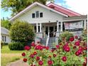 Two-story home with red roof, white trim, large front porch, and blooming red roses at 322 4Th Sw St, Hickory, NC 28602