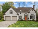 Charming two-story home with a well-manicured lawn, two-car garage, and inviting orange front door at 6319 High Creek Ct, Charlotte, NC 28277