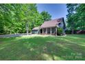 Inviting home exterior with a wide, green lawn and a covered front porch amidst lush trees at 6688 Pine Forest Dr, York, SC 29745