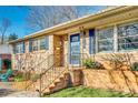 Inviting brick home exterior with blue door and well-maintained landscaping at 6956 Oakstone Pl, Charlotte, NC 28210