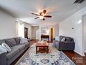 Cozy living room with hardwood floors, ceiling fan, front door entrance and comfortable gray sofas at 7120 Furlow Ln, Harrisburg, NC 28075