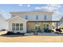 The back of the home has a covered patio with comfortable furniture, a dining area, and a fire pit at 8310 Sandstone Crest Ln, Indian Land, SC 29707