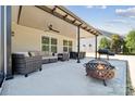Spacious covered patio with comfortable seating, dining area, and a fire pit, perfect for outdoor gatherings at 8310 Sandstone Crest Ln, Indian Land, SC 29707