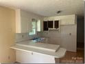 Functional kitchen space with ample cabinets, countertops, and an eat-in breakfast bar at 1327 Crestview Dr, Shelby, NC 28150