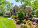This brick home is framed by colorful landscaping and a well-manicured lawn at 13358 Bally Bunnion Way, Davidson, NC 28036