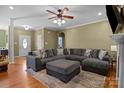 Spacious living room featuring hardwood floors, a fireplace, and a large sectional sofa with an ottoman at 150 Hidden Oak Dr, Statesville, NC 28677