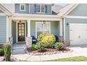 Inviting front porch featuring stone accents and stylish outdoor seating, framed by beautiful landscaping at 152 Broadleaf Dr, Denver, NC 28037