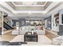 Bright open living space showcasing travertine flooring, a tray ceiling, and seamless connection to the kitchen at 16455 Harbor View Rd, Charlotte, NC 28278
