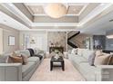A spacious living area featuring a decorative ceiling, a view of the stairway, and modern, neutral furnishings at 16455 Harbor View Rd, Charlotte, NC 28278