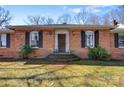Classic brick home featuring a stylish front door with decorative windows and manicured landscaping at 1751 5Th Ne St, Hickory, NC 28601