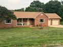 Charming brick home featuring a covered porch, lush lawn, and a convenient attached two-car garage at 1922 Dogwood Flower Ln, Lincolnton, NC 28092
