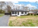 Inviting white brick home with a well-manicured lawn, black shutters, and a welcoming front door with wreath at 2318 Knight Dr, Gastonia, NC 28052