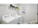 Bright laundry room with white washer and dryer, wire shelving, and decorative wall art at 315 Brinkley Dr, Kings Mountain, NC 28086
