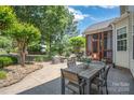 Spacious patio with dining table, seating area, and lush greenery at 6141 Abergele Ln, Matthews, NC 28104