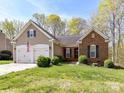 Traditional home with brick and siding, a two-car garage, and a green front lawn at 7507 Reedy Creek Rd, Charlotte, NC 28215