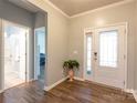 Welcoming foyer with wood floors, white trim, and natural light shining through the front door at 8828 Powder Works Dr, Huntersville, NC 28078