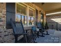 Inviting porch featuring rocking chairs, decorative shutters, and a stylish patterned rug at 944 Clear Creek Cir, Lincolnton, NC 28092