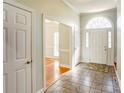 Inviting foyer with tiled floor, white door with glass sidelights and view to the light-filled living room at 105 Partridge Bluff Ne Dr, Concord, NC 28025