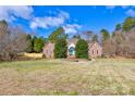 Charming brick home with a well-manicured front yard, mature trees, and blue front door at 105 Partridge Bluff Ne Dr, Concord, NC 28025