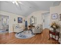 Bright living room featuring vaulted ceilings, hardwood floors, two chairs, and an area rug at 121 Yorkshire Dr, Salisbury, NC 28144