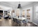 Inviting dining area featuring a modern chandelier, ample natural light, and hardwood floors at 16115 Chiltern Ln, Huntersville, NC 28078