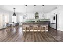 Modern kitchen with white cabinets, stainless steel appliances, an island and pendant lighting at 16115 Chiltern Ln, Huntersville, NC 28078