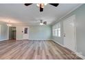 Open living area with light walls, wood floors, ceiling fans, and bright natural light from the large windows at 200 South Fork Dr, Shelby, NC 28152
