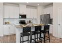 Modern kitchen with white cabinets, stainless steel appliances, and granite countertops with breakfast bar at 2106 Morgan Hills Dr, Albemarle, NC 28001
