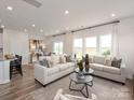 Bright living room with neutral tones, wood flooring, and multiple windows for natural light at 2106 Morgan Hills Dr, Albemarle, NC 28001