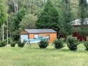 Outbuilding exterior with wood siding, metal roof, and a boat parked outside at 211 Honeycutt Rd, Troutman, NC 28166