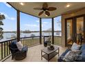Relaxing screened-in porch overlooking the lake, furnished with comfortable seating and a ceiling fan at 213 Morgan Bluff Rd, Mooresville, NC 28117
