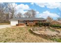 A single-story brick home with manicured shrubs, contrasted by a prominent stone-edged planting area at 4014 Linwood Rd, Gastonia, NC 28052