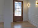 Stylish foyer features a decorative glass front door, hardwood floors, and elegant wall sconces at 4227 Holly Ne Cir, Conover, NC 28613