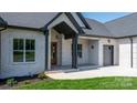 Inviting brick porch with Craftsman style columns and a warm wood front door entrance at 4227 Holly Ne Cir, Conover, NC 28613